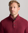 Model is wearing UNTUCKit Cable-Knit Button Neck Sweater in red. 