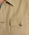 Model is wearing UNTUCKit chadwick herringbone over shirt in tan. 
