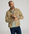 Model is wearing UNTUCKit chadwick herringbone over shirt in tan. 