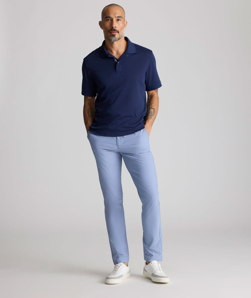 Model is wearing UNTUCKit traveler pants in stone wash.