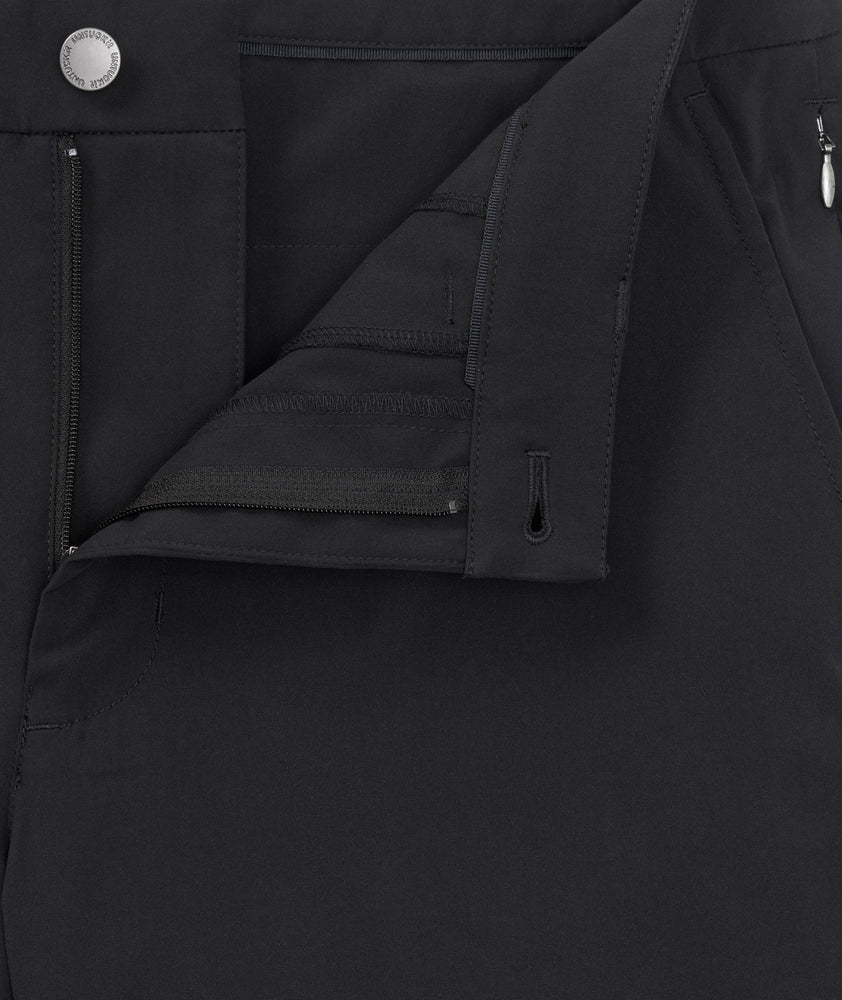 Model is wearing UNTUCKit 7" Traveler Tech Shorts in black. 