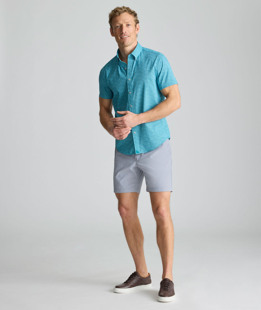 Model is wearing UNTUCKit 7" Traveler Tech Shorts in gray. 