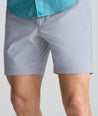 Model is wearing UNTUCKit 7" Traveler Tech Shorts in gray. 