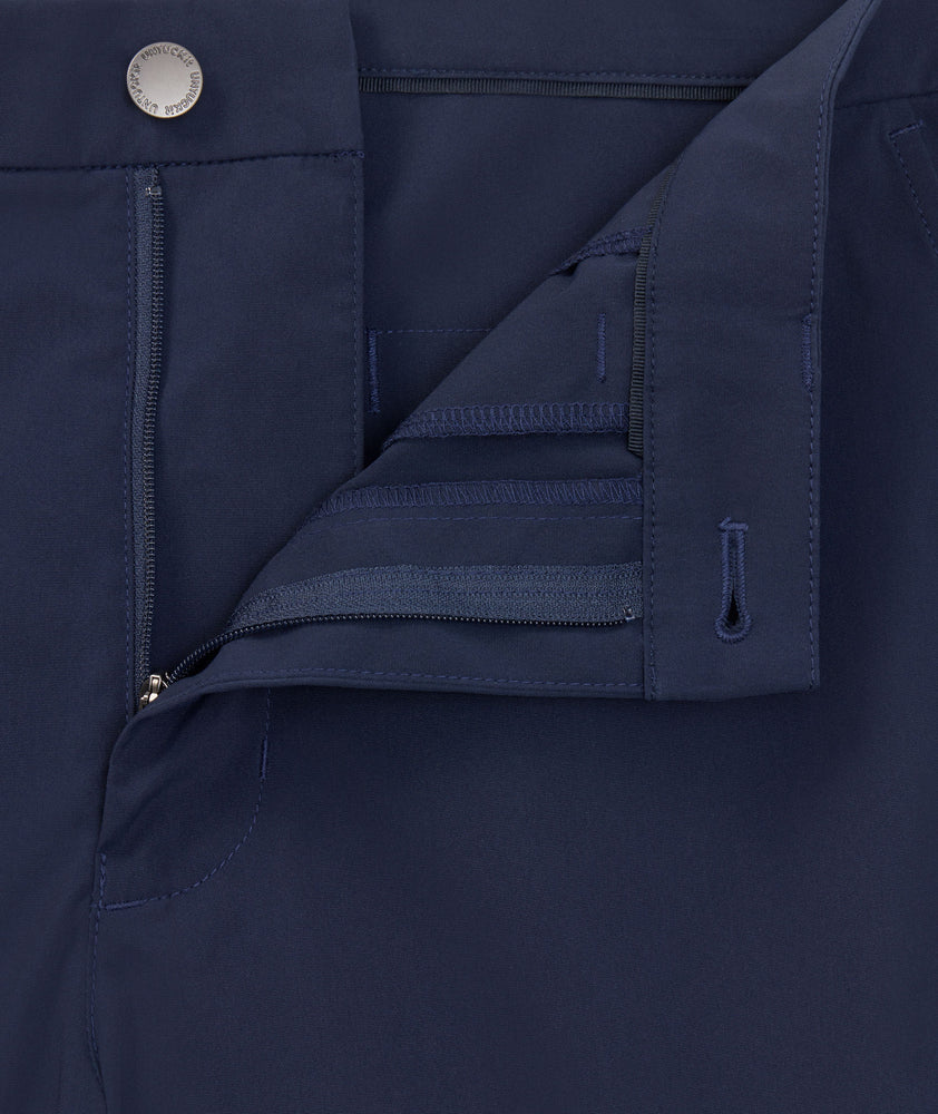 Model is wearing UNTUCKit 7" Traveler Tech Shorts in navy. 