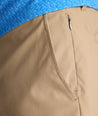 Model is wearing UNTCKit 7" Traveler Tech Shorts in Khaki. 