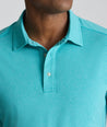 Model is wearing UNTUCKit Performance Polo in teal. 
