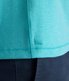 Model is wearing UNTUCKit Performance Polo in teal. 