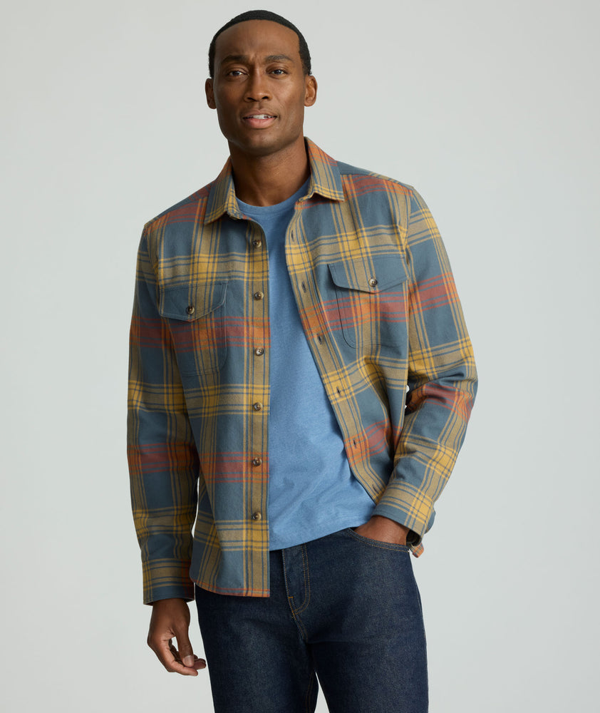 Model is wearing UNTUCKit Brushed Overshirt in Gray, Yellow, & Orange Plaid.