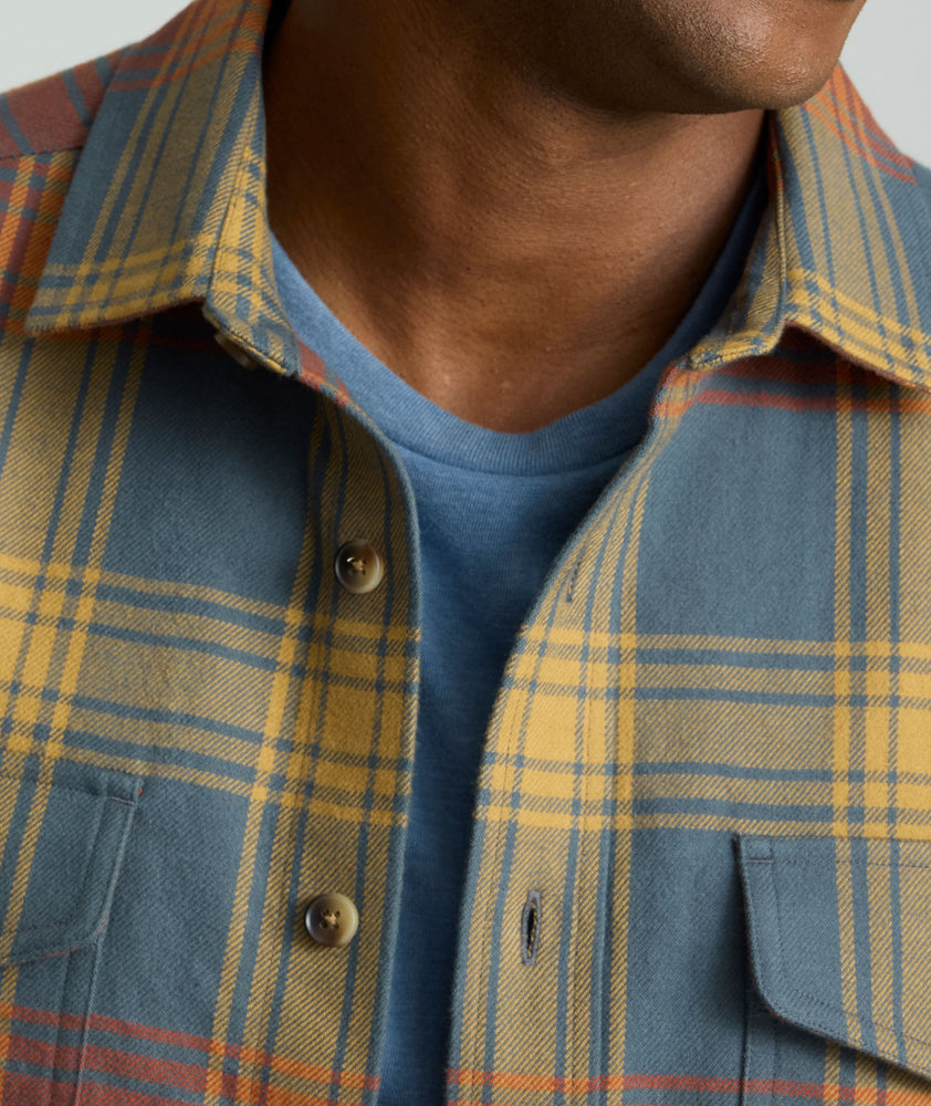 Model is wearing UNTUCKit Brushed Overshirt in Gray, Yellow, & Orange Plaid.
