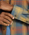 Model is wearing UNTUCKit Brushed Overshirt in Gray, Yellow, & Orange Plaid.
