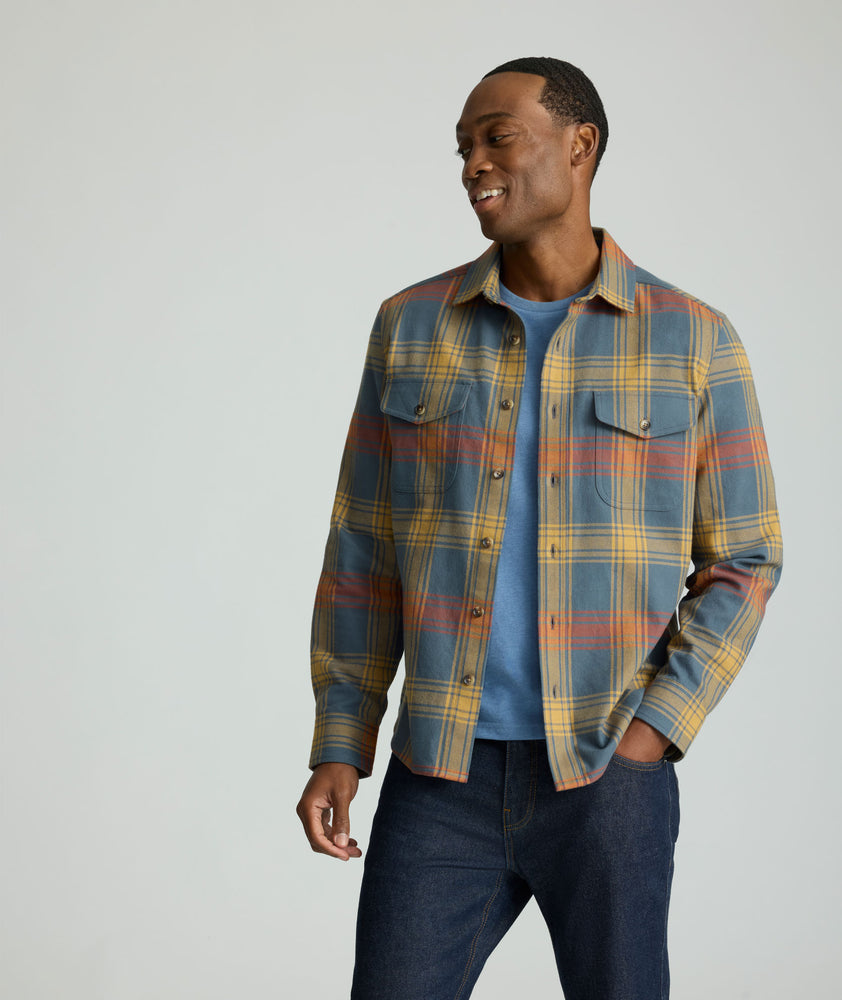 Model is wearing UNTUCKit Brushed Overshirt in Gray, Yellow, & Orange Plaid.