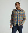 Model is wearing UNTUCKit Brushed Overshirt in Gray, Yellow, & Orange Plaid.