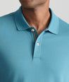 Model is wearing UNTUCKIt Wrinkle-Free Damaschino Polo in teal. 