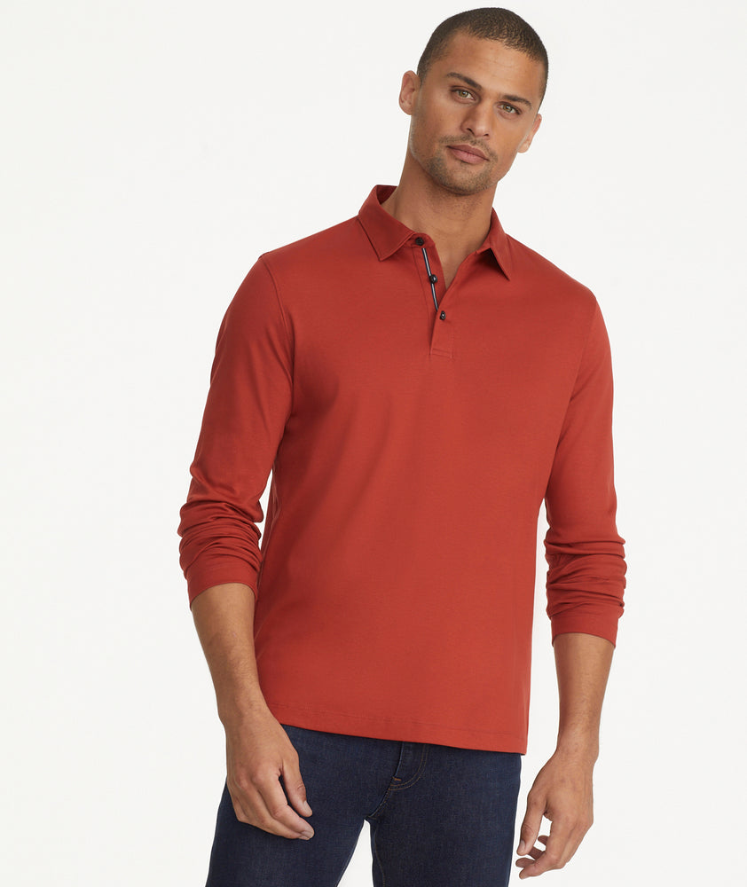 Model is wearing UNTUCKit damaschino long sleeve polo in solid chili.