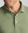 Model is wearing UNTUCKit Wrinkle-Free Damaschino Long-Sleeve Polo in Heather Sage. 