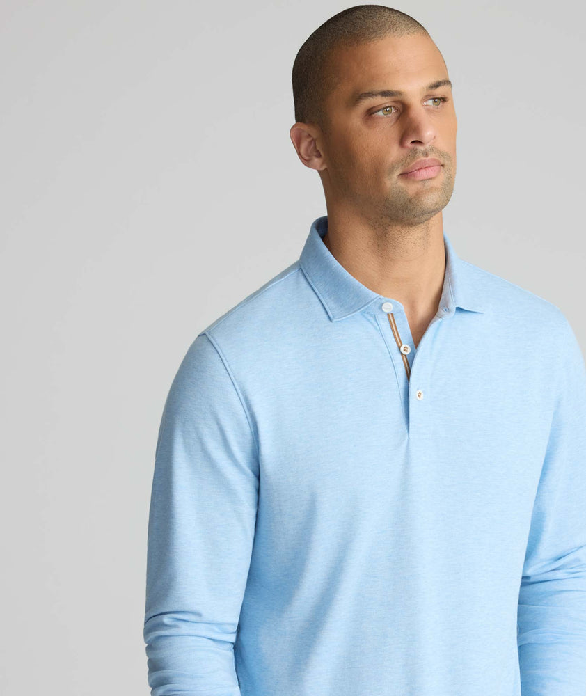Model is wearing UNTUCKit Wrinkle-Free Damaschino Long-Sleeve Polo in Heather Light Blue. 