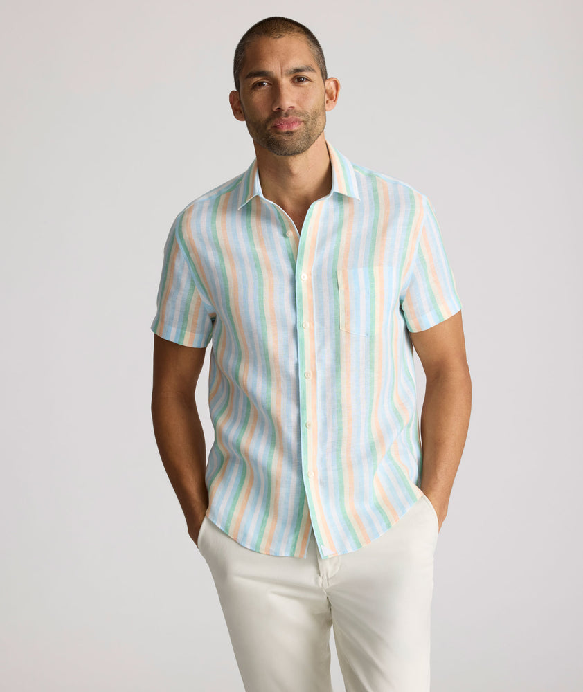 Model is wearing UNTUCKit darby wrinkle-free shirt in rainbow stripe. 