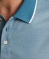 Model is wearing UNTUCKit LS Day Performance Polo in Real Teal.