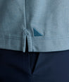 Model is wearing UNTUCKit LS Day Performance Polo in Real Teal.