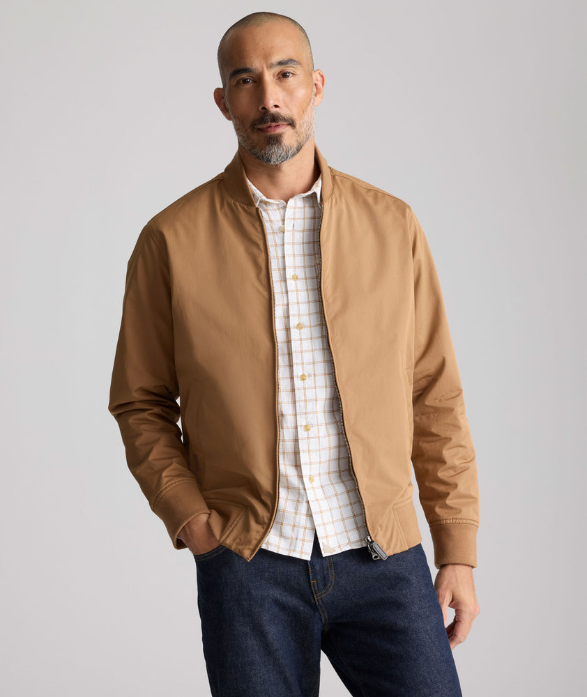 Model is wearing UNTUCKit Cotton Blend Bomber Jacket in tan. 