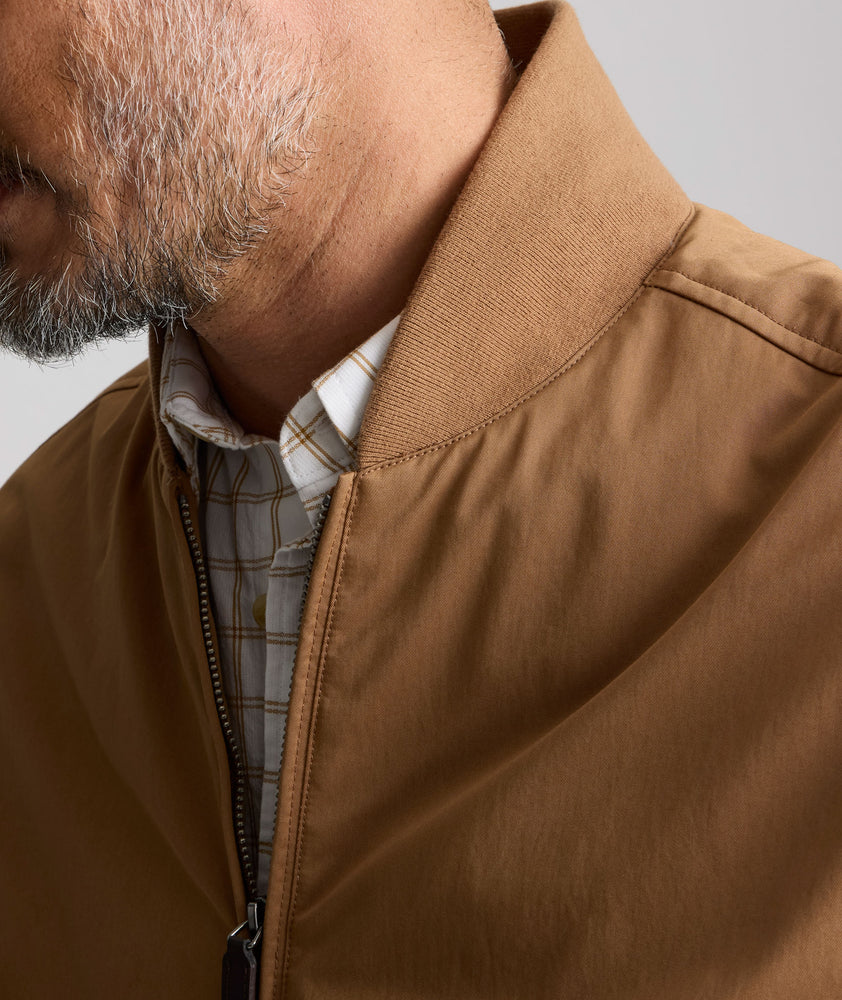 Model is wearing UNTUCKit Cotton Blend Bomber Jacket in tan. 