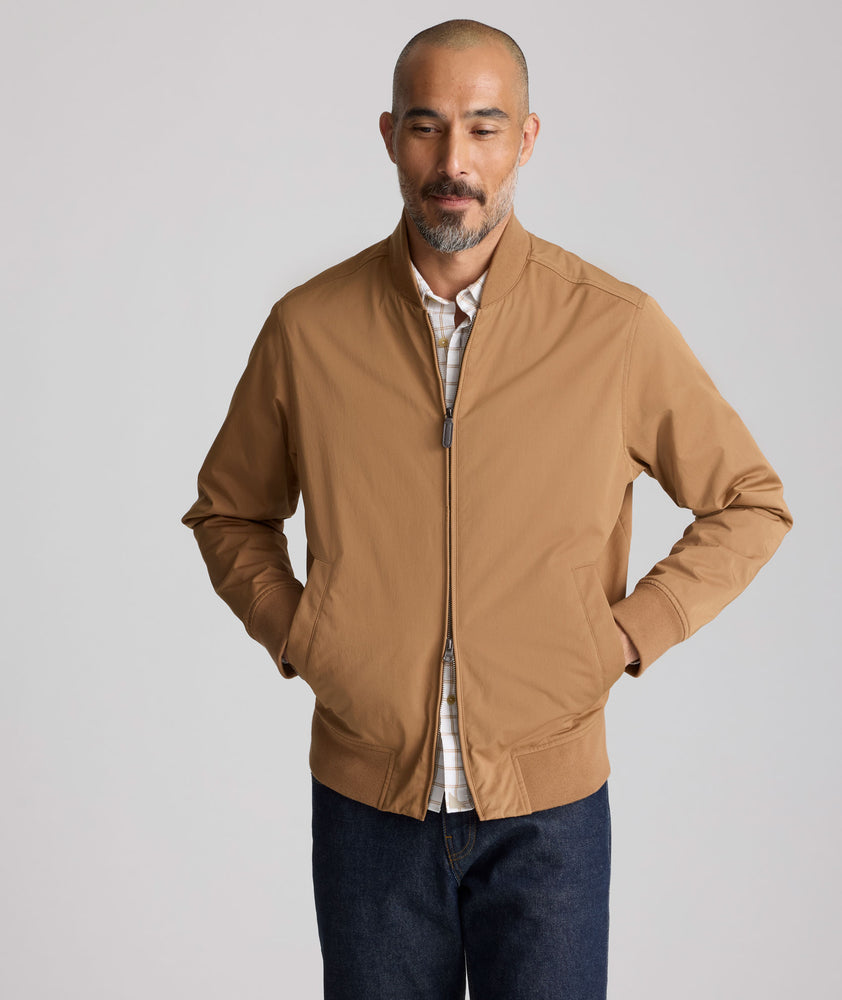 Model is wearing UNTUCKit Cotton Blend Bomber Jacket in tan. 