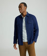 Model is wearing UNTUCKit Brushed Overshirt in navy. 