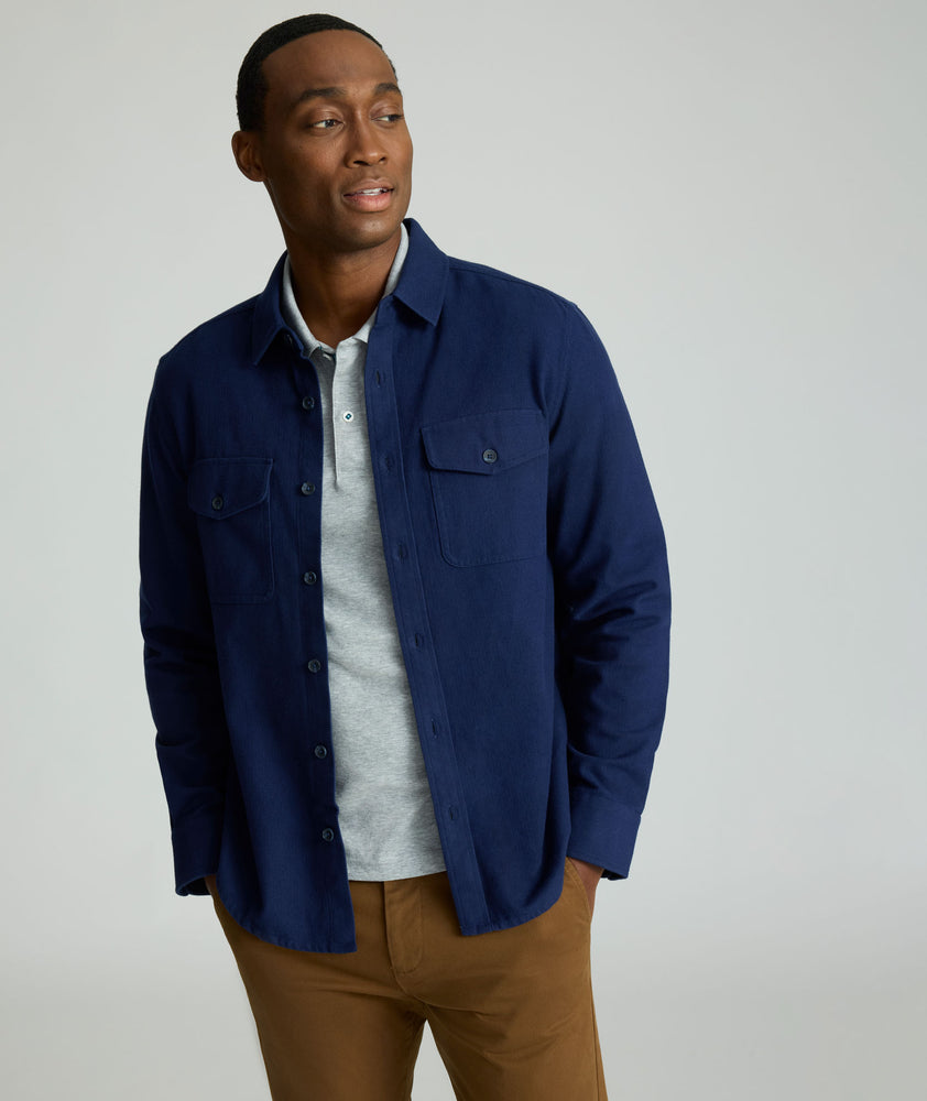 Model is wearing UNTUCKit Brushed Overshirt in navy. 