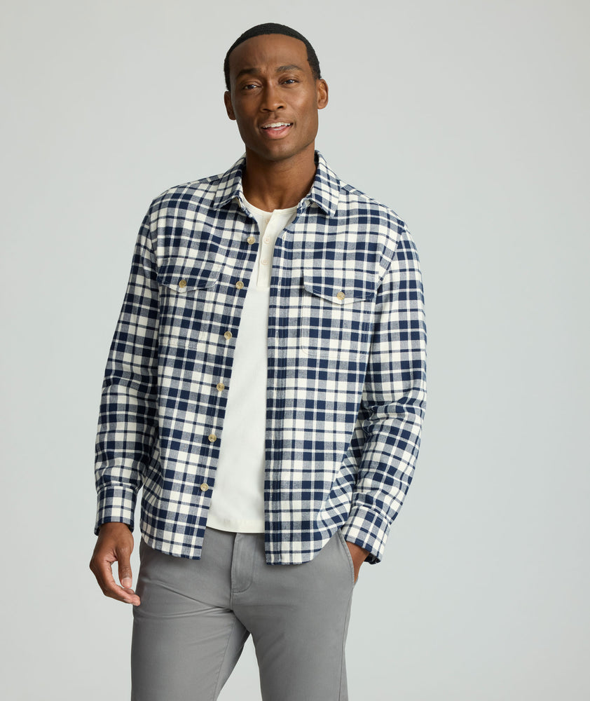 Model is wearing UNTUCKit Brushed Overshirt in navy and white check. 