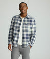 Model is wearing UNTUCKit Brushed Overshirt in navy and white check. 