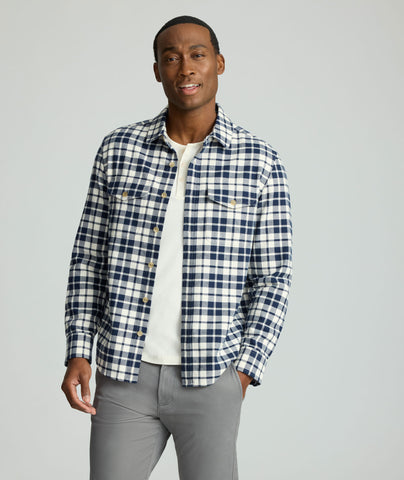 Model is wearing UNTUCKit Brushed Overshirt in navy and white check. 