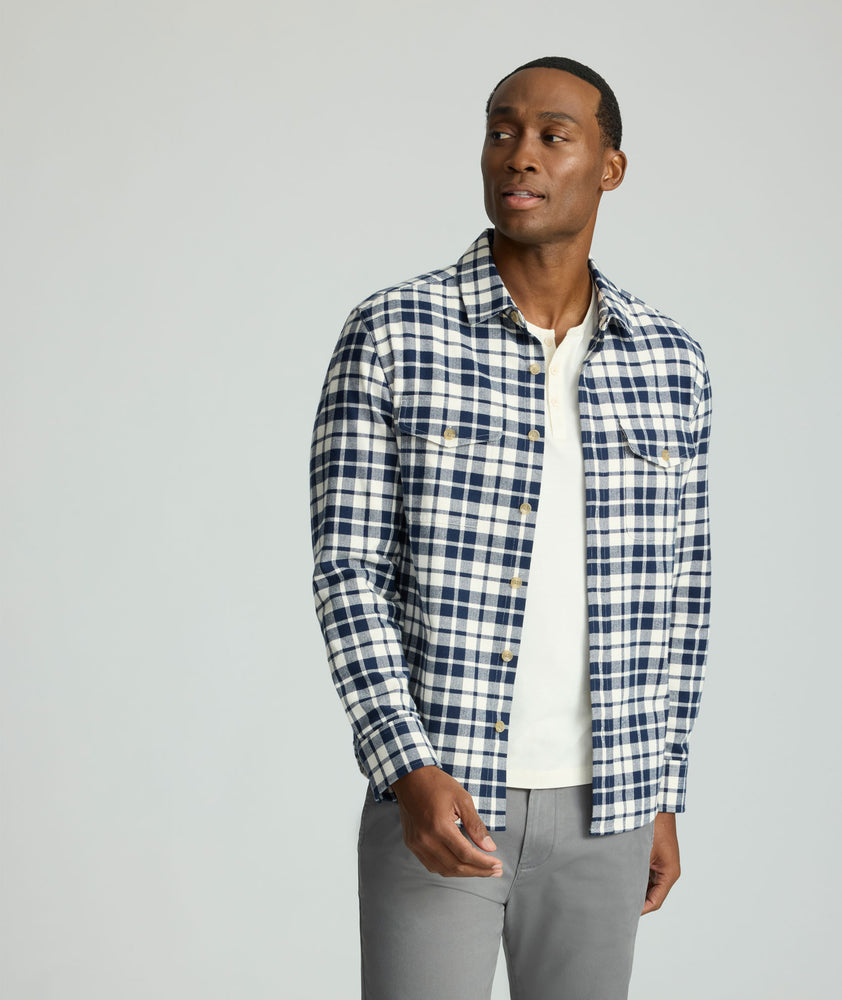 Model is wearing UNTUCKit Brushed Overshirt in navy and white check. 