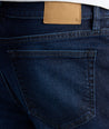 Close-up of blue jeans with a brown leather patch on the back pocket.