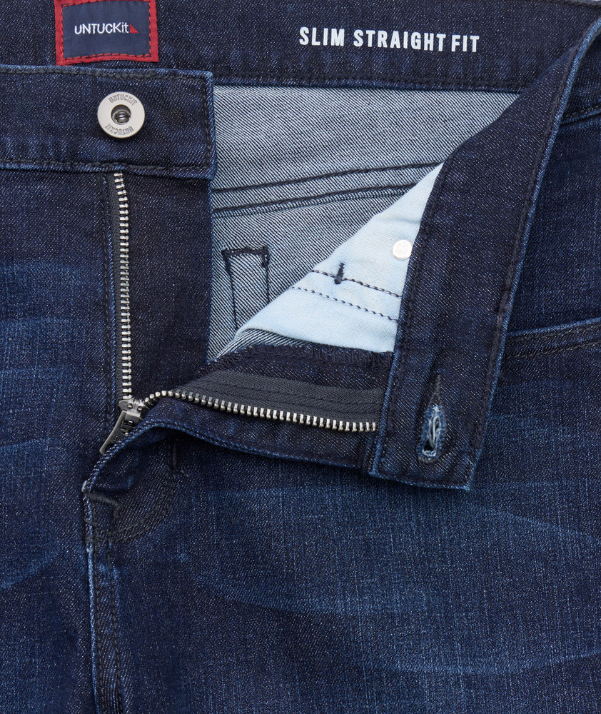 Close-up of a blue denim jacket with 'Untuckit' branding and 'Slim Straight Fit' text.