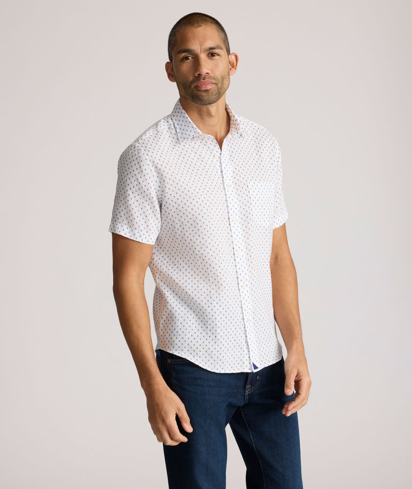 Model is wearing UNTUCKit Dixon short sleeve shirt with white grounded Dimond print. 