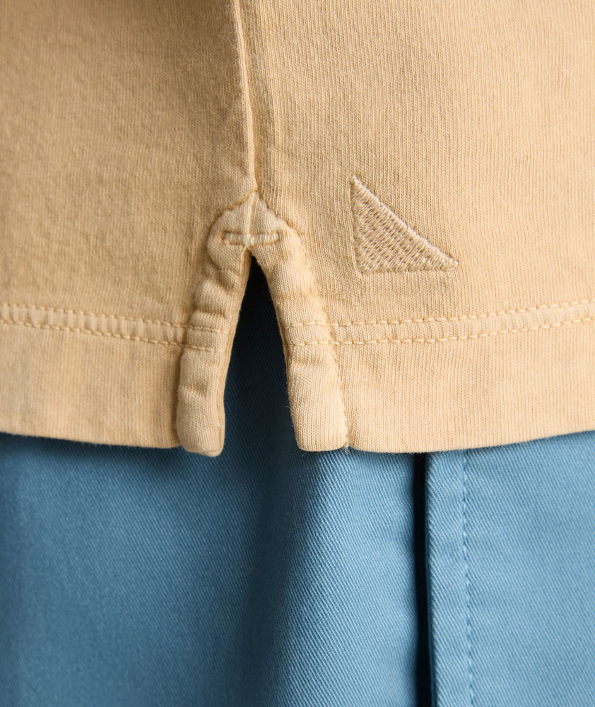 Model is wearing UNTUKit Vintage Wash Polo in Garment Dyed orange. 