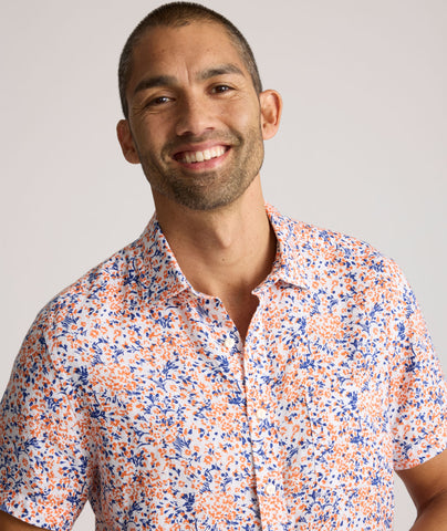 Model is wearing UNTUCKit Ellsworth Short Sleeve shirt in orange and blue floral. 