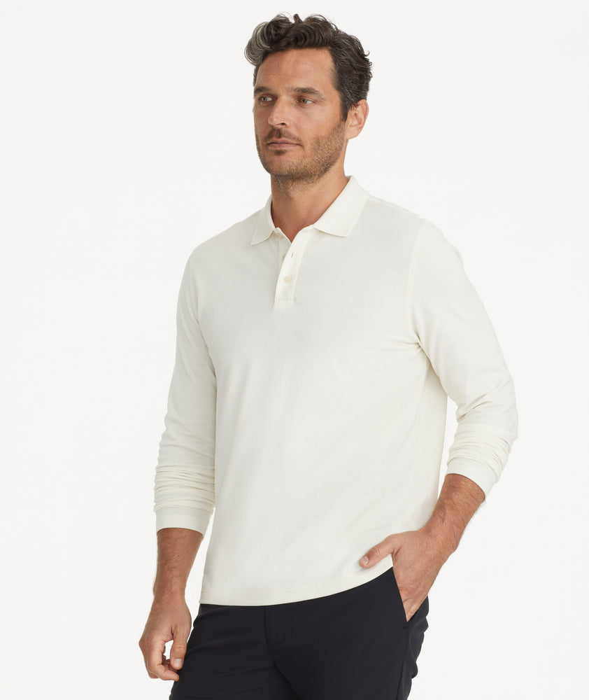Model is wearing UNTUCKit Elvira long sleeve polo in vanilla ice.