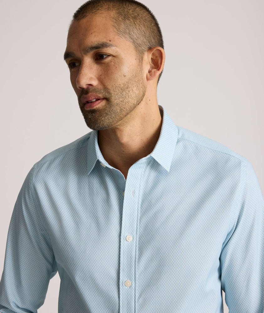 Model is wearing UNTUCKit Falkirk performance shirt in blue print. 