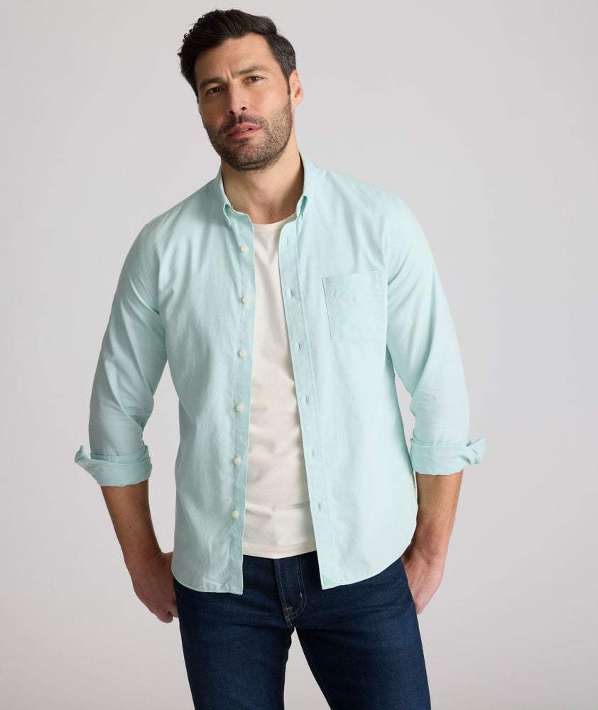 Model is wearing UNTUCKit Farnsworth in vintage wash solid marine blue. 
