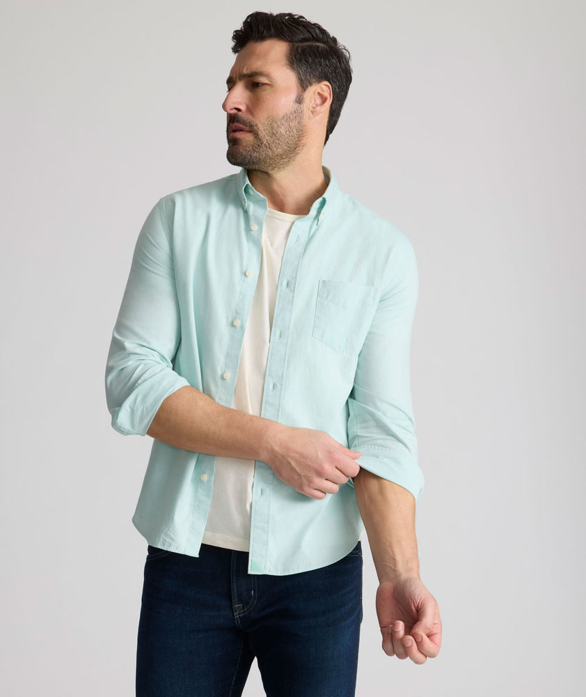 Model is wearing UNTUCKit Farnsworth in vintage wash solid marine blue. 