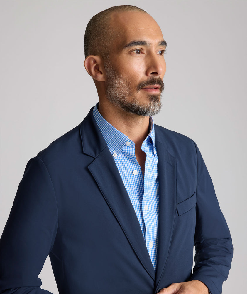 Model is wearing UNTUCKit Performance Blazer in navy. 