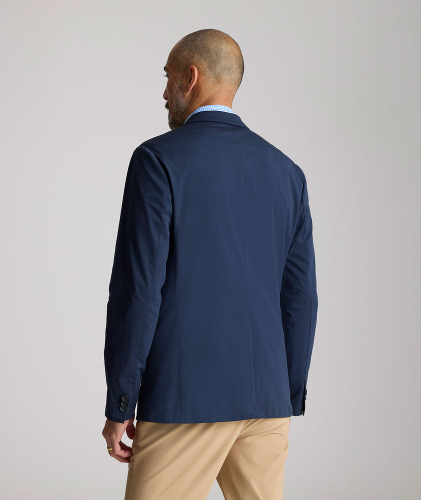 Model is wearing UNTUCKit Performance Blazer in navy. 