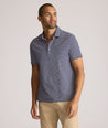 Model is wearing UNTUCKit Fernandez Striped Performance Polo in Blue Print.