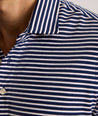 Model is wearing UNTUCKit Fernandez Striped Performance Polo in Blue Print.