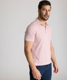 Model is wearing UNTUCKit Fernandez Striped Performance Polo in Pink Quartz.