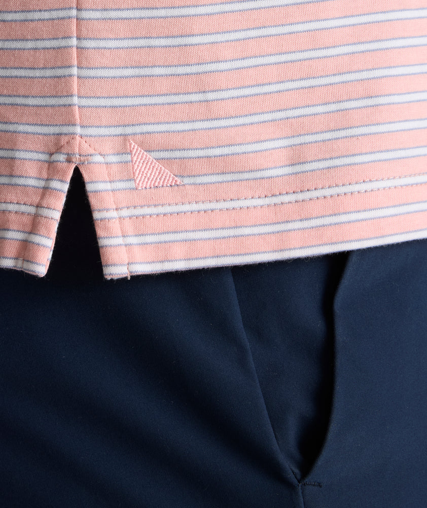 Model is wearing UNTUCKit Fernandez Striped Performance Polo in Pink Quartz.