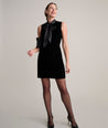 Model is wearing UNTUCKIt fiona velvet black dress. 