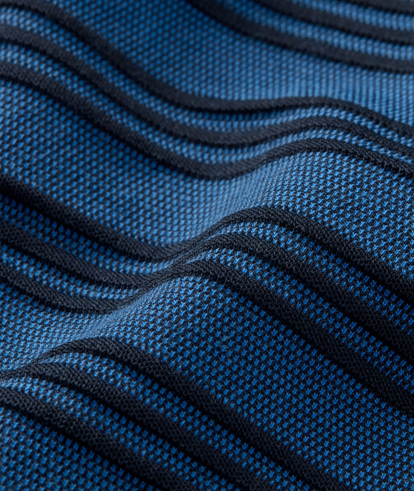 Model is wearing UNTUCKit Performance Hybrid Polo in dark blue. 