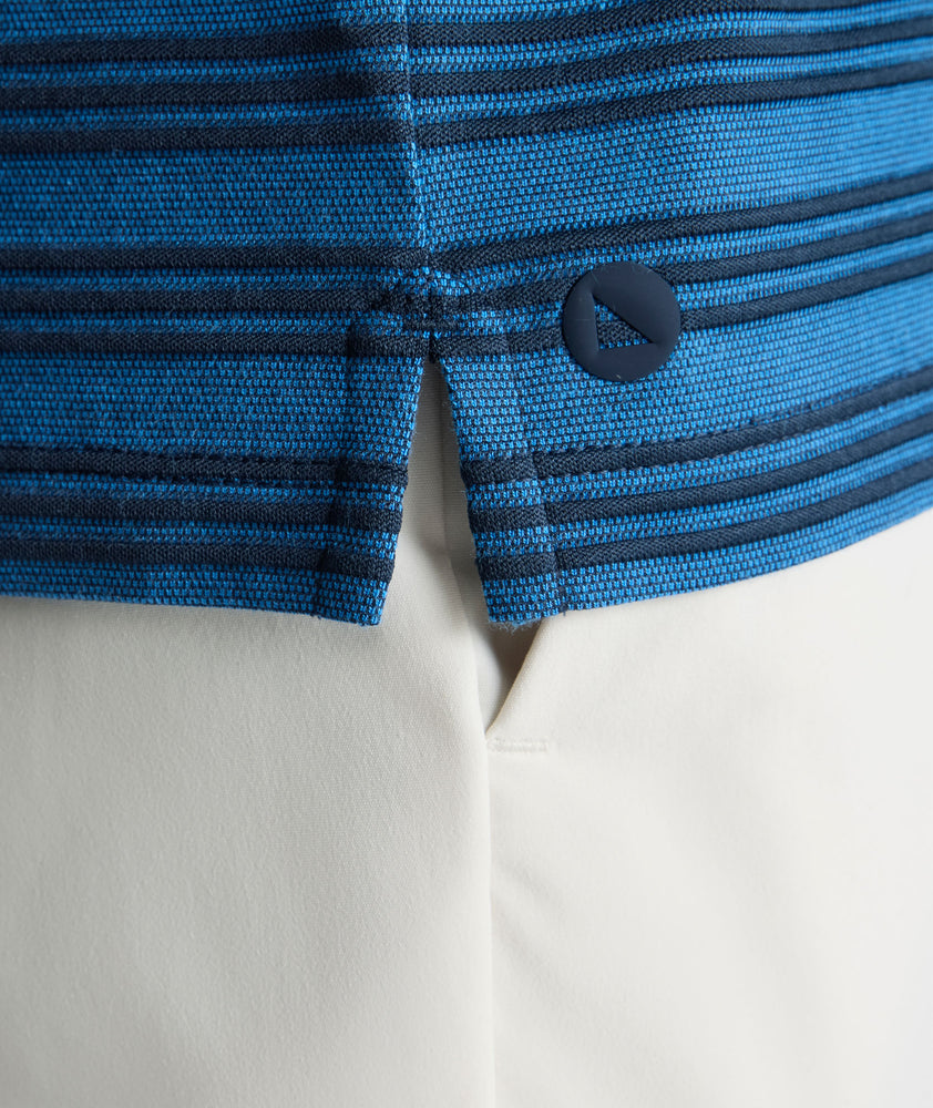 Model is wearing UNTUCKit Performance Hybrid Polo in dark blue. 